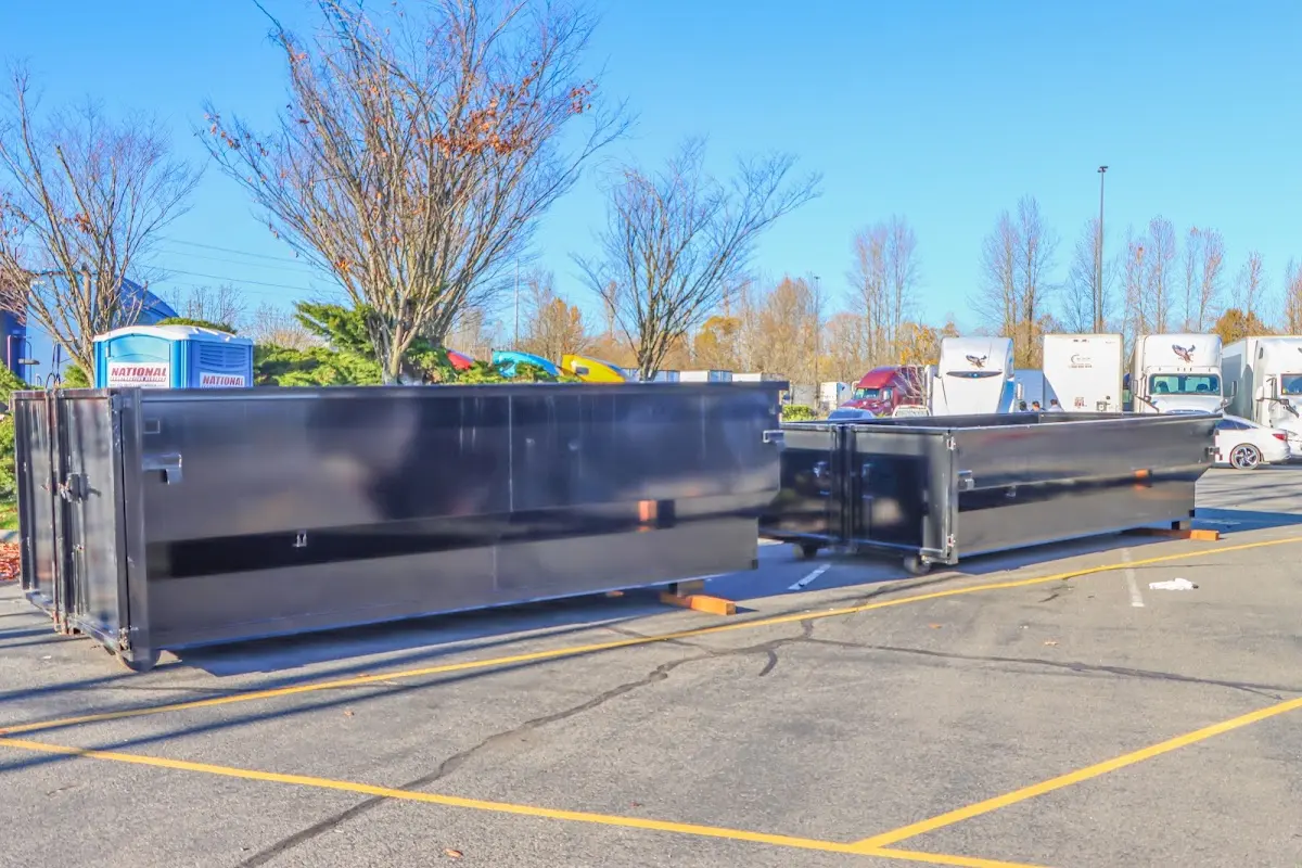 Professional dumpster rental service with roll-off container on residential driveway in Adelanto